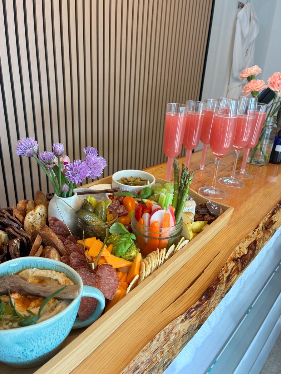 Charcuterie board with cured meats, cheese, crudités and a row of pink mocktails at Contrast by Raven