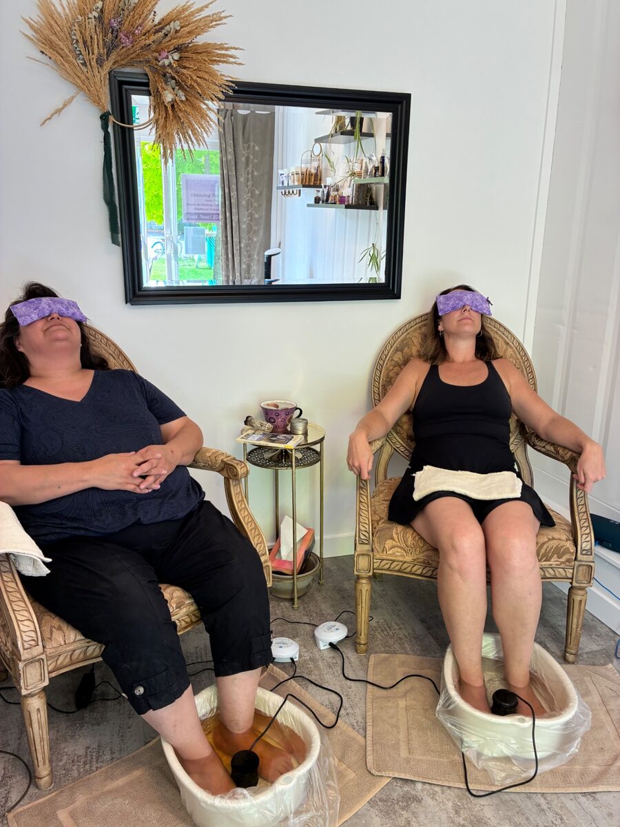 Two guests relaxing with eye pillows during a detox foot bath at Contrast by Raven